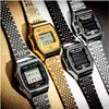 Four Casio digital watches with metal bands are arranged diagonally on a textured surface. Produktbild-Vorschau