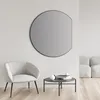 A modern living room scene with a chair, coffee table, and a large round mirror on the wall. Anteprima dell’immagine prodotto