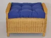 A close-up, front-facing view of a wicker ottoman with a blue cushion. Produktbild-Vorschau