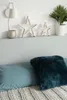 A shelf with decorative stars and a plant above a bed with pillows. Produktbild-Vorschau