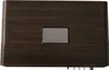 A close-up, top-down view of a dark wood-grained speaker with a metallic plaque in the center. Voir les images du produit