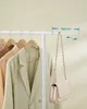 A clothes rack with several garments and a handbag hanging from it, with a measurement overlay. Náhled obrázku produktu
