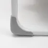 Close-up of a corner of a white frame with a gray plastic protector. Produktbild-Vorschau