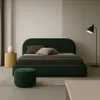 A minimalist bedroom scene featuring a dark green upholstered bed. Anteprima dell’immagine prodotto