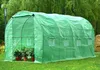 A green greenhouse with plants inside, set up on a lawn with trees in the background. Náhľad obrázku produktu