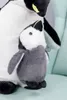 A close-up of two plush penguins, one larger and one smaller, sitting on a light blue surface. Podgląd zdjęcia produktu