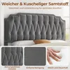 A close-up of a gray upholstered headboard with three smaller inset images showing fabric texture, a hand pressing into a soft surface, and a detail of the tufted fabric. Produktbild-Vorschau