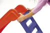 A person's hands are shown assembling a red and blue plastic slide. Anteprima dell’immagine prodotto