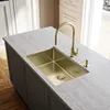 A modern kitchen island with a gold sink and faucet. Podgląd zdjęcia produktu