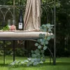 Deko-Szene: Eukalyptus-Girlande mit Rose und Sekt auf Bank Produktbild-Vorschau