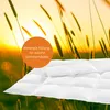 A close-up of a white comforter with a sunset and tall grass in the background. Voir les images du produit