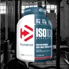 A large tub of Dymatize ISO 100 hydrolyzed whey protein powder in strawberry flavor, set against a black and white background of gym equipment. Produktbild-Vorschau