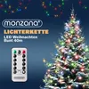 A decorated Christmas tree with colorful lights and a remote control for the lights. Produktbild-Vorschau
