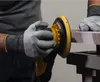 A person wearing gloves is using a yellow and black orbital sander on a wooden surface. Produktbild-Vorschau