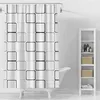A white shower curtain with a black grid pattern is displayed in a bathroom setting, next to a white shelving unit. Produktbild-Vorschau