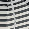 Close-up view of the internal structure of a striped umbrella. Voir les images du produit