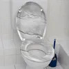A toilet with a marble-patterned seat and lid, with a blue toilet brush holder next to it. Produktbild-Vorschau
