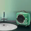 A green vintage-style fan heater is placed on a dark countertop next to a sink and faucet. Náhled obrázku produktu