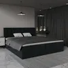 A dark gray upholstered bed with two pillows and a dark gray duvet is shown in a bedroom setting. Náhled obrázku produktu