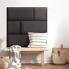 A dark gray upholstered headboard is mounted on a white wall, with a wooden bench in front of it. A striped pillow rests on the bench, and a striped blanket is draped over the side. Two woven baskets are placed on the floor next to the bench. Anteprima dell’immagine prodotto