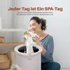 A woman is smelling a towel that is coming out of a towel warmer. Podgląd zdjęcia produktu