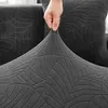 A hand is stretching a dark grey sofa cover with a leaf pattern. Produktbild-Vorschau