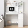 A white computer desk with shelves and drawers, featuring a monitor displaying the time. Náhľad obrázku produktu