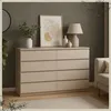 A dresser with 8 drawers is shown in a room setting with artwork and a lamp on top. Produktbild-Vorschau