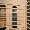 Close-up view of the interior of a wooden sauna cabin, showing heating elements and ventilation grilles. Produktbild-Vorschau
