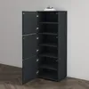 A dark gray shoe cabinet with three open doors, revealing shelves inside, placed against a light gray wall and on a wooden floor. Produktbild-Vorschau