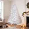 A white artificial Christmas tree is set up in a living room with a fireplace and decorations. Produktbild-Vorschau