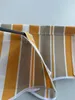 A close-up view of a striped awning fabric wrapped around a dark pole. Produktbild-Vorschau
