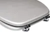 A close-up, angled view of a silver toilet seat and lid, showing the hinges. Produktbild-Vorschau