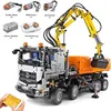 A detailed product shot of a remote-controlled construction vehicle, with components laid out. Voir les images du produit