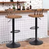 Two bar stools are shown in front of a tiled wall and a wooden counter with bottles on it.
