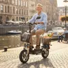A man rides an electric scooter along a canal in a European city. Náhled obrázku produktu