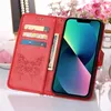 A red leather iPhone 14 Plus case with a butterfly embossed design and card slots is shown open, displaying an iPhone 14 Plus screen. Produktbild-Vorschau