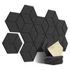 A collection of black hexagonal acoustic panels arranged in a geometric pattern, with a stack of panels and adhesive backing in the foreground. Produktbild-Vorschau