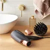 A bathroom countertop with a sink, faucet, hairdryer, diffuser, and a bottle of perfume. Anteprima dell’immagine prodotto