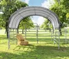 A portable shelter with a steel frame and tarp cover, set up in a grassy field with trees in the background. Two bales of hay are placed in front of the shelter. Produktbild-Vorschau