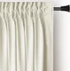 A close-up view of cream-colored curtains hanging from a black curtain rod. Podgląd zdjęcia produktu