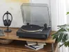 A turntable and headphones are displayed on a wooden shelf, with a plant in the background. Voir les images du produit