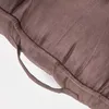 A close-up view of a brown sofa cushion with a handle. Náhled obrázku produktu