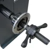 A close-up view of a mechanical component, likely part of a larger machine, with a threaded shaft and a wingnut-style adjustment mechanism. Produktbild-Vorschau