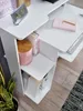 A white computer desk with shelves, a clock, a pink container, books, and a keyboard. Produktbild-Vorschau