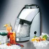 A chrome and white ice crusher is shown with several cocktails and garnishes, surrounded by ice. Náhled obrázku produktu