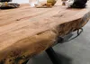 A close-up view of a wooden table with a live edge and black metal legs. Produktbild-Vorschau