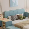 A child's bedroom with a blue upholstered bed, pillows, and a small desk attached to the side. Voir les images du produit