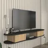 A modern TV lowboard mounted on a wall with a television and decorative items. Podgląd zdjęcia produktu