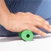 A hand is pressing a green foam roller against a blue textured surface. Anteprima dell’immagine prodotto